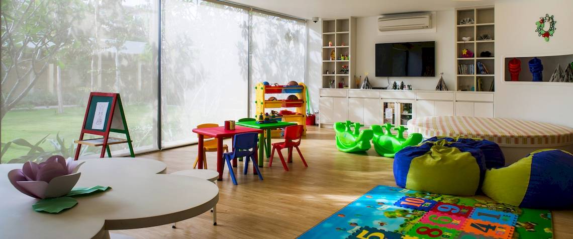 Kinderzimmer im Salinda Resort Phu Quoc Island mit bunten Möbeln, Teppich und Fernseher.
