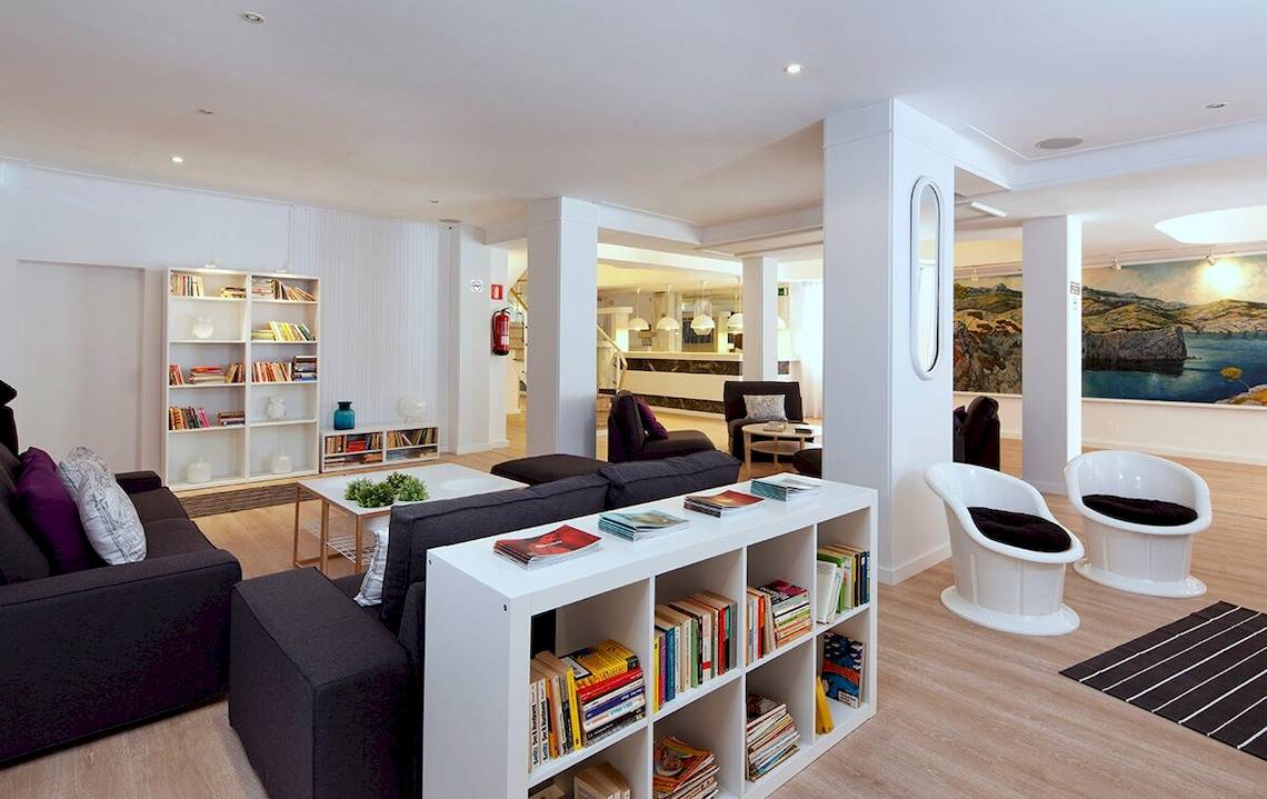 Innenansicht des Whala Beach Hotel-Lobbys mit Möbeln, Büchern und Dekoration.