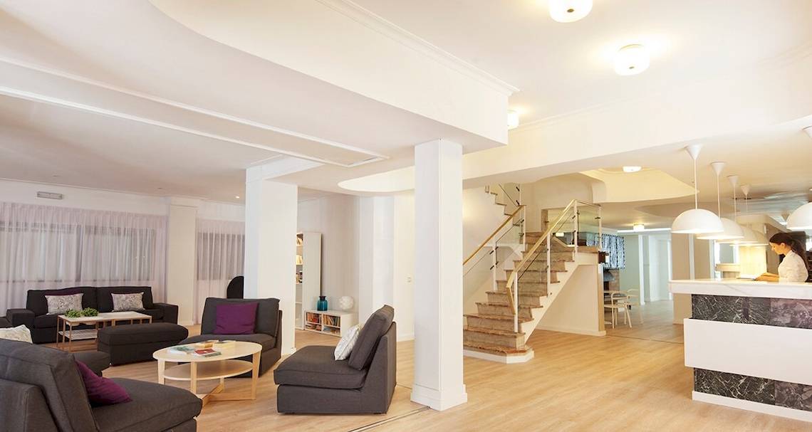 Whala Beach Hotel Innenbereich mit Wohnzimmer, Couches, Tisch und Treppenhaus