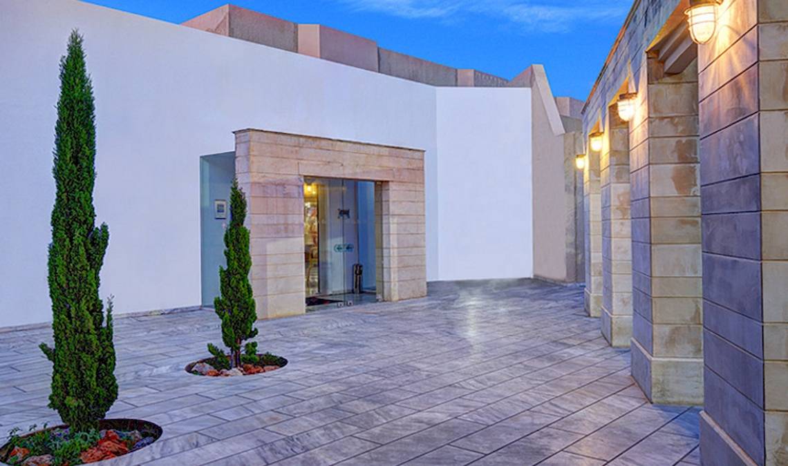 Eingang des Giannoulis Santa Marina Beach Hotels mit gepflastertem Boden und Pflanzen