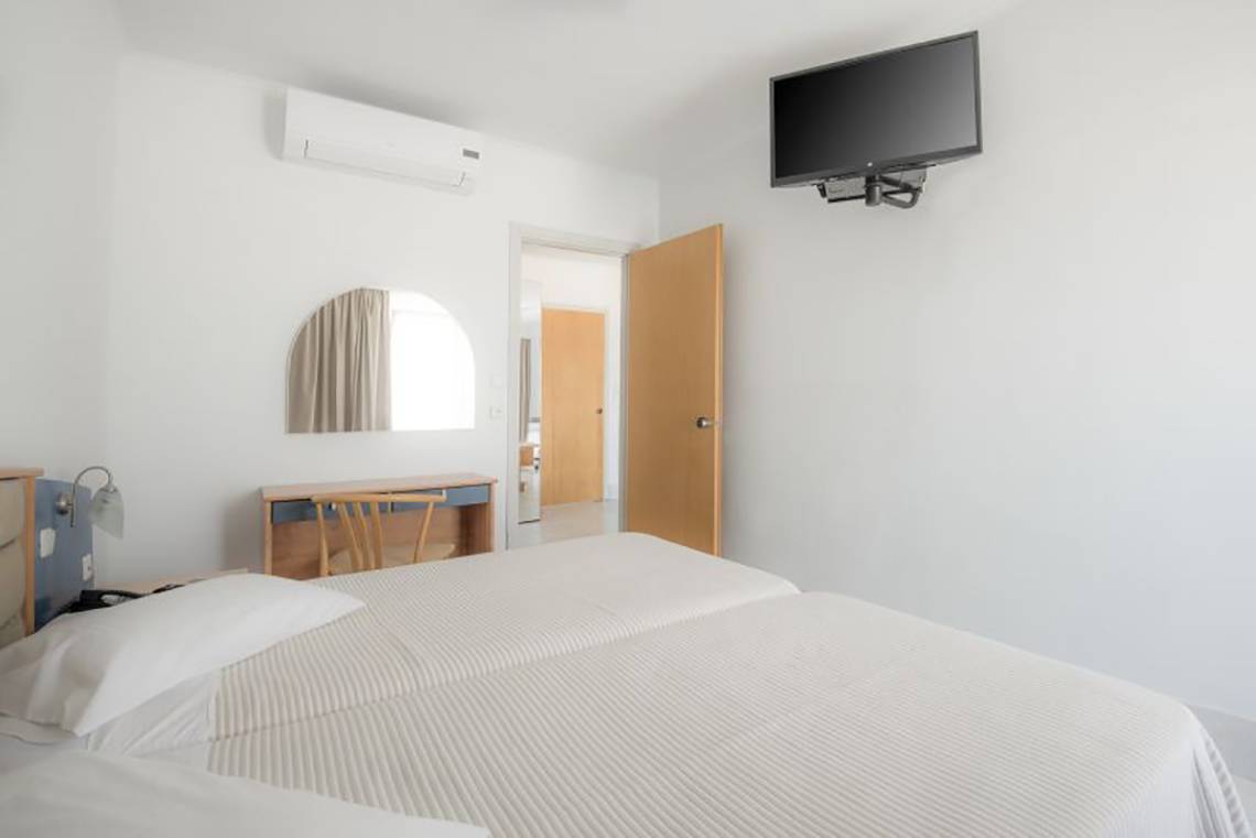 Doppelzimmer im Kosta Palace City Hotel mit zwei Betten, Klimaanlage und Fernseher an der Wand.