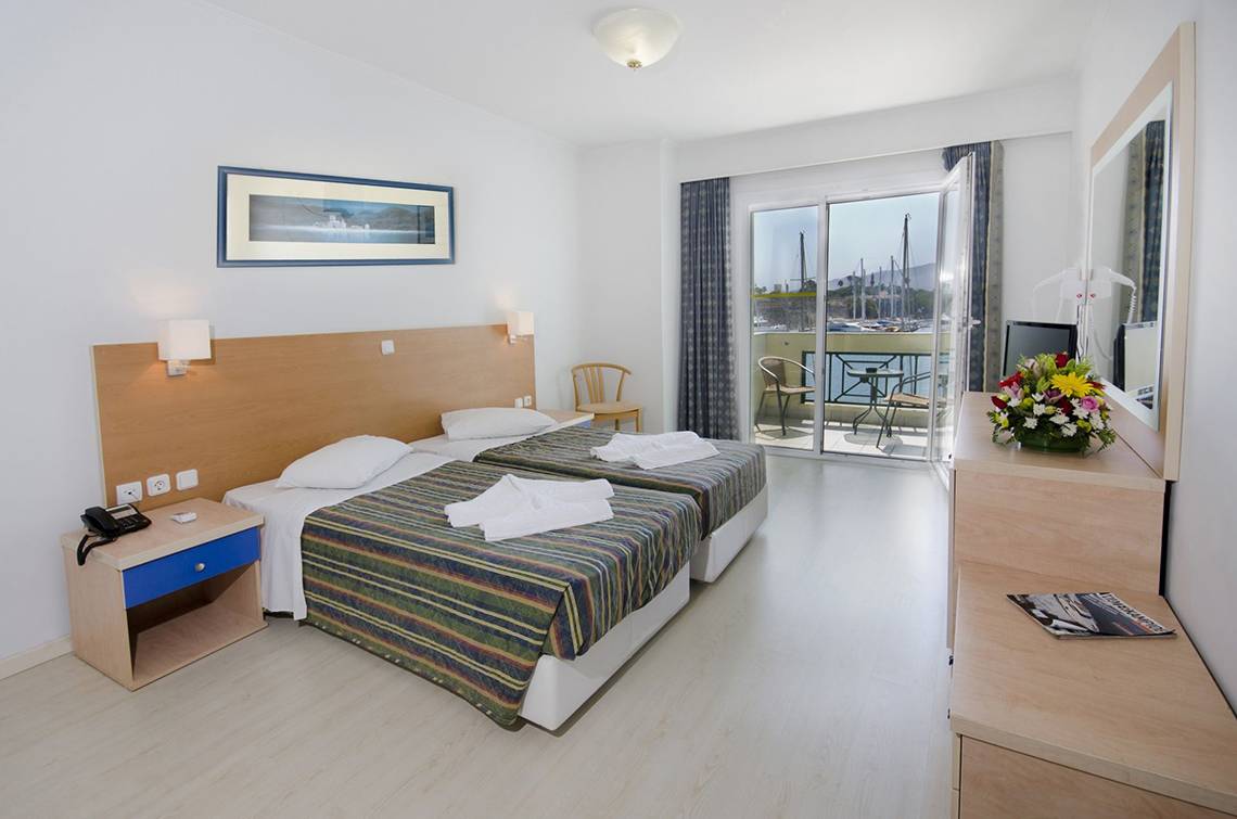 Doppelzimmer im Kosta Palace City Hotel mit zwei Betten, einem Balkon und Meerblick.