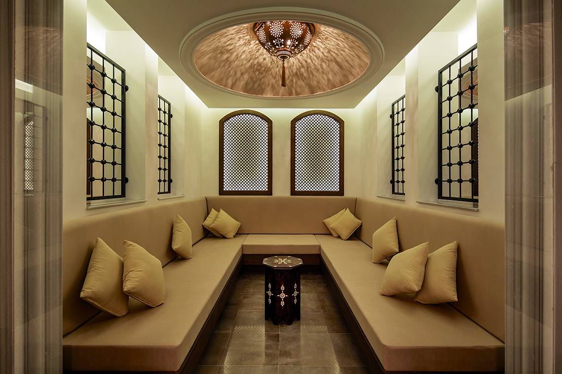 Lounge Bereich im Titanic Deluxe Golf Belek Hotel mit runden Sofas und Fenstern.