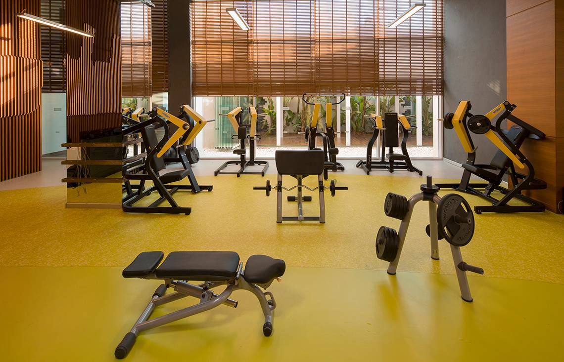Fitnessstudio im Titanic Deluxe Golf Belek Hotel mit gelbem Boden und Trainingsgeräten