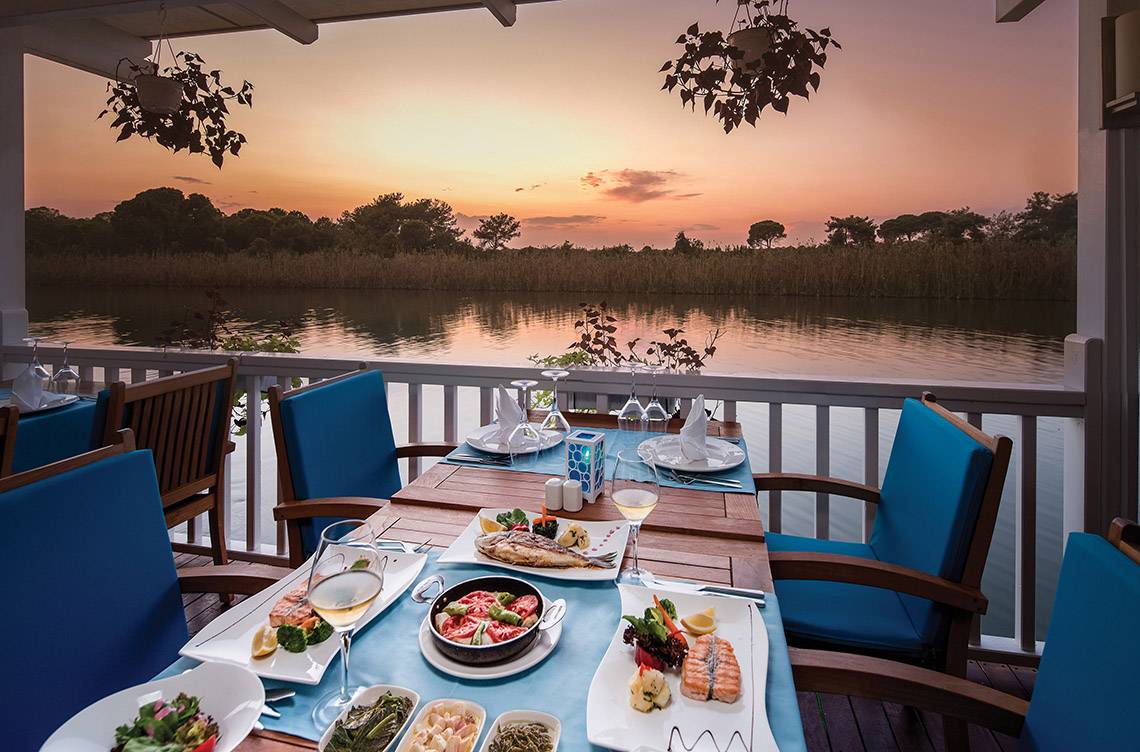 Außentisch mit Blick auf den See während des Sonnenuntergangs im Titanic Deluxe Golf Belek