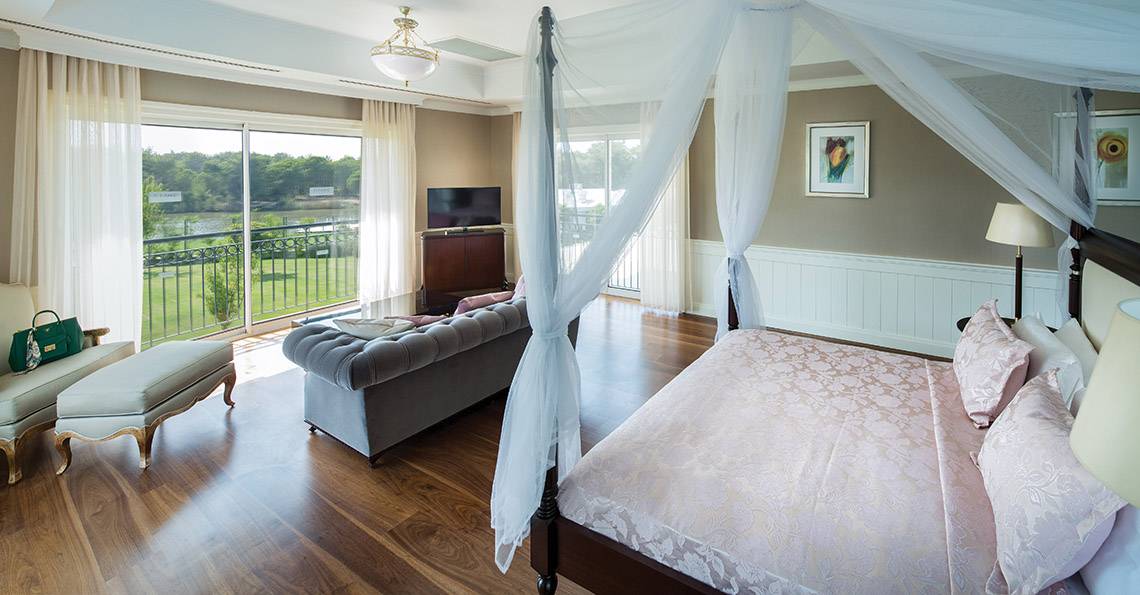 Schlafzimmer im Titanic Deluxe Golf Belek Hotel mit Himmelbett, Sofa und Fernseher