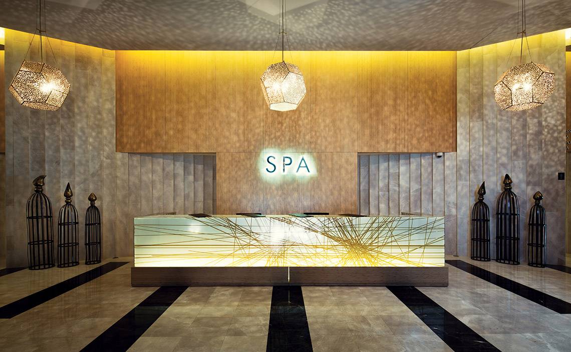 Empfangsbereich des Spas im Titanic Deluxe Golf Belek Hotel mit goldenem Design und 'SPA' Schild.