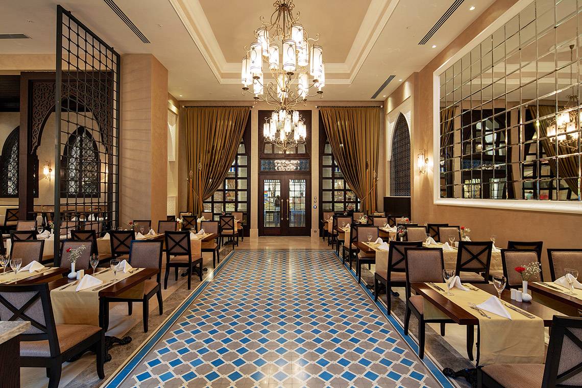 Innenbereich eines Restaurants im Titanic Deluxe Golf Belek Hotel mit gemusterten Fliesen und luxuriöser Einrichtung.
