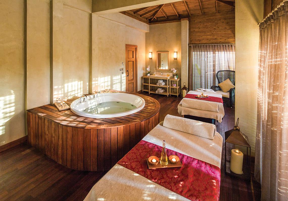 Innenansicht des Wellnessbereichs im Titanic Deluxe Golf Belek mit einer großen Badewanne und Massageliegen.