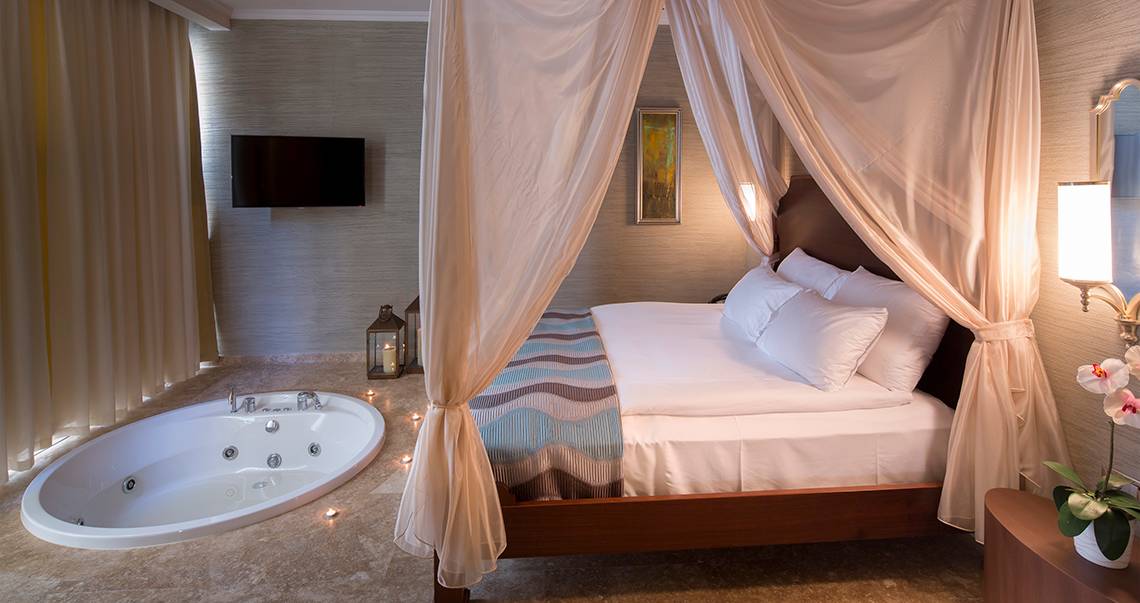 Ein Zimmer im Titanic Deluxe Golf Belek mit Bett, Whirlpool und Fernseher.