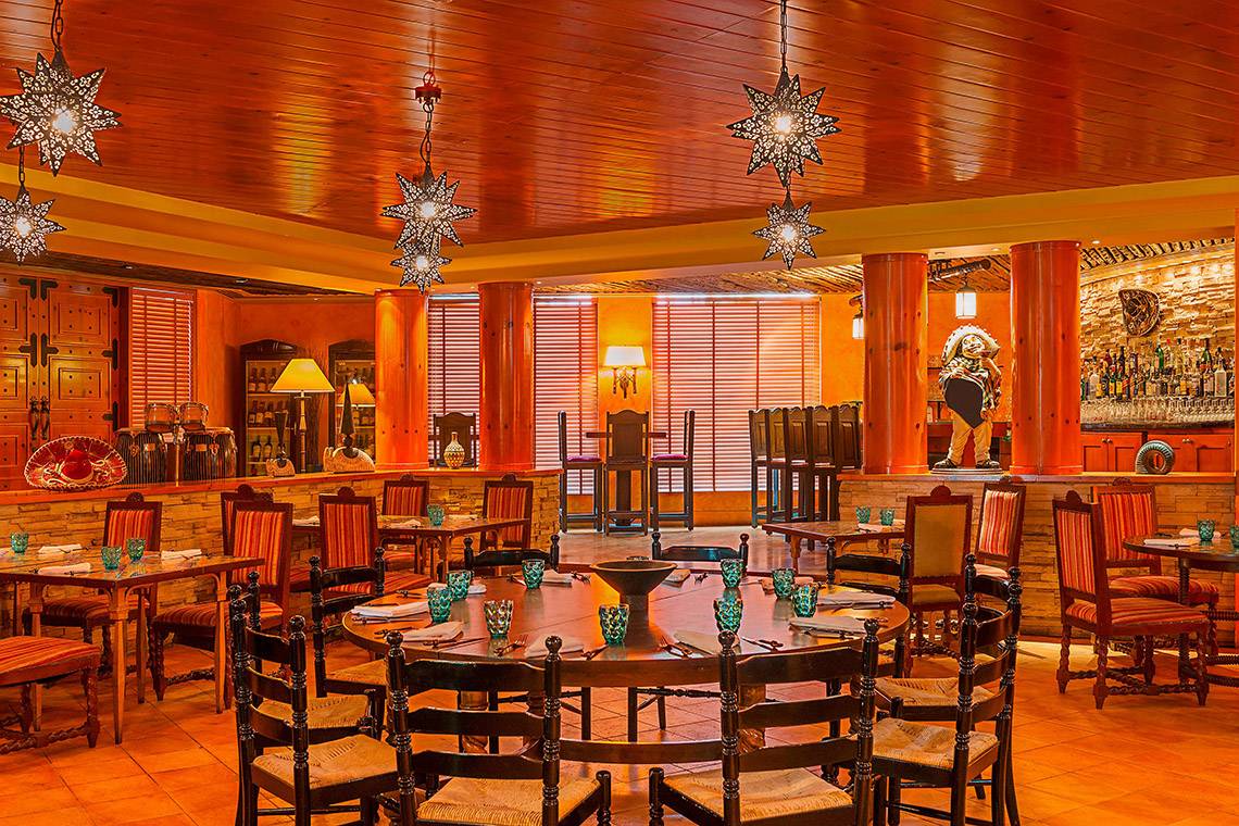 Innenansicht des Restaurants im Sheraton Abu Dhabi Hotel & Resort mit runden Tischen und Stühlen.