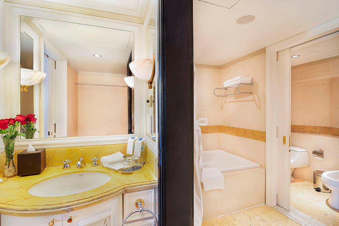 Badezimmer im Sheraton Abu Dhabi Hotel & Resort mit Spiegel, Waschbecken, Toilette und Badewanne.