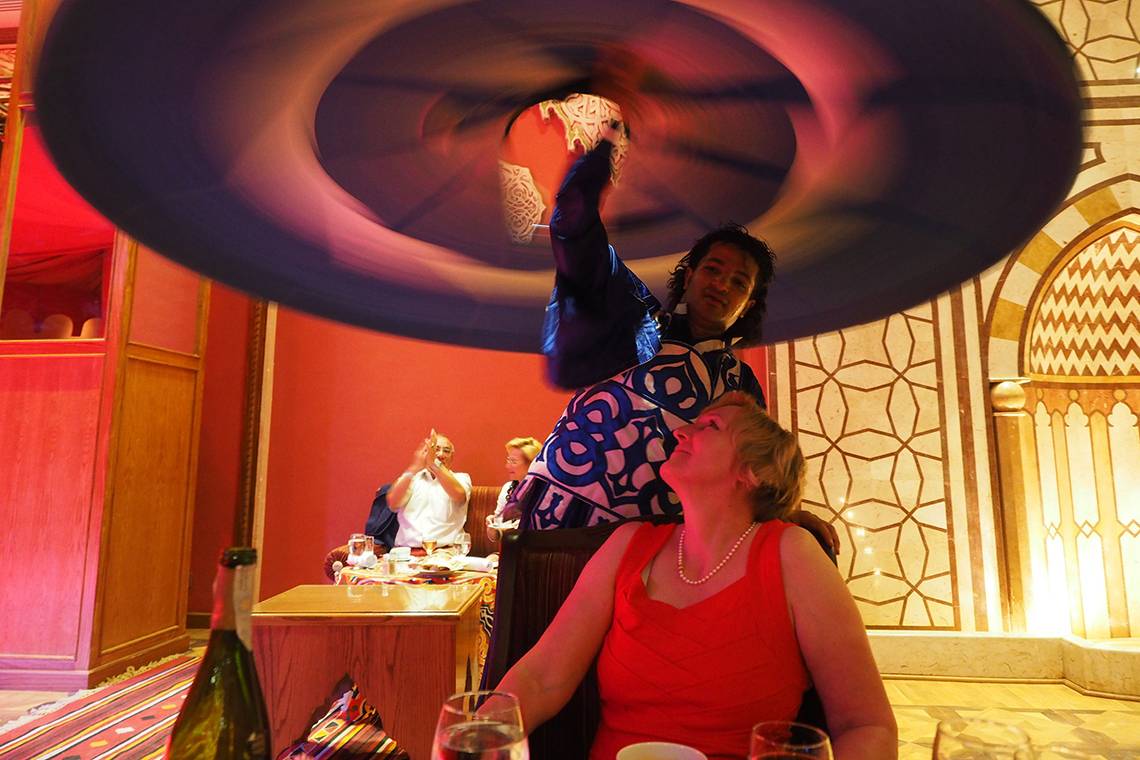 Ein Mann serviert ein Gericht über einem Tisch im Makadi Spa Hotel Restaurant.