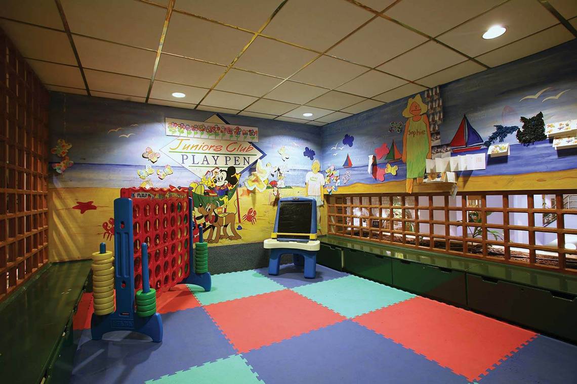 Spielzimmer im GrandResort Limassol mit bunten Wandmalereien und Spielen wie Connect Four.