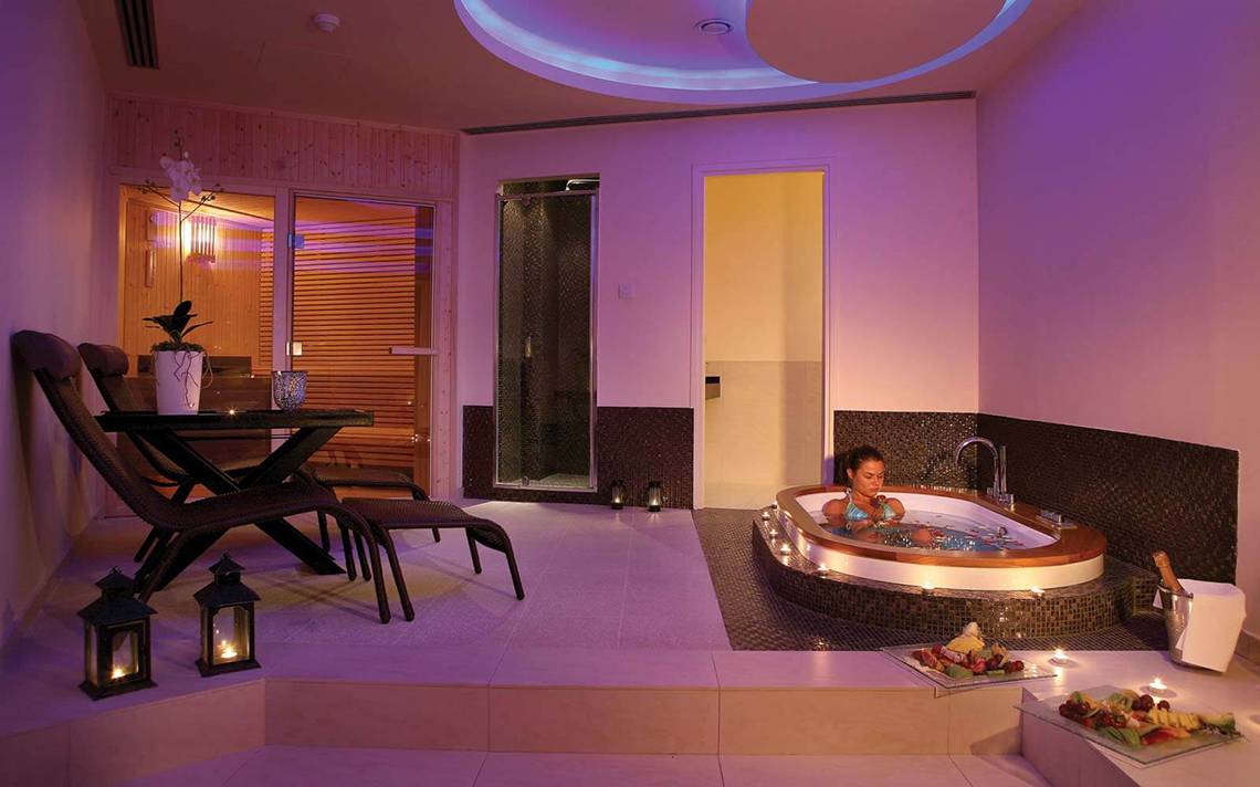 Innenansicht der Jacuzzi-Lounge im GrandResort Limassol mit einer Frau im Whirlpool.