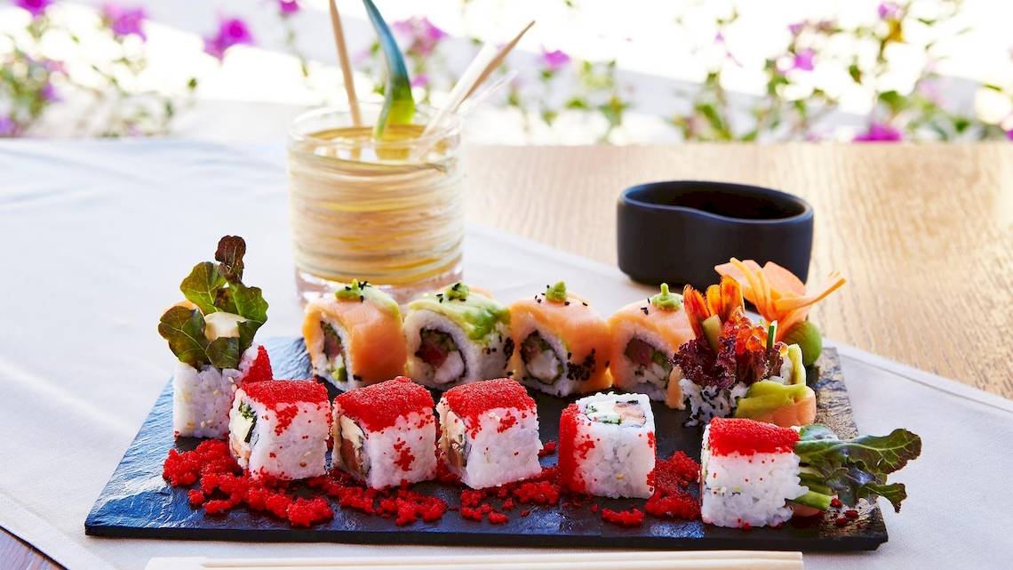 Eine Platte mit verschiedenen Sushi-Rollen auf einem Holztisch im Kempinski Hotel Soma Bay.