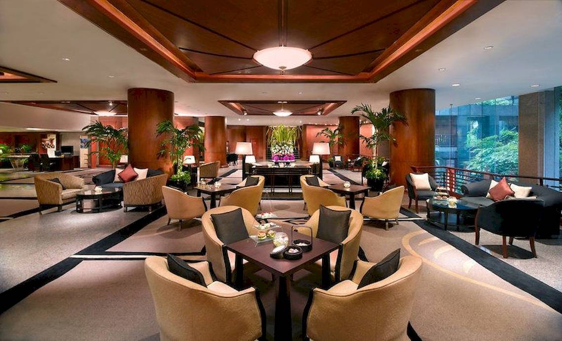 Lobbybereich des Banyan Tree Bangkok mit Sofas, Tischen und Pflanzen.