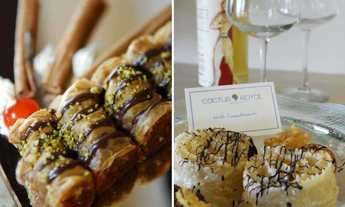 Nahrungsmittel und Getränke im Cactus Royal Hotel, einschließlich Desserts mit Schokolade und Pistazien sowie Gläser mit Wein.