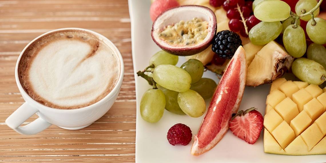 Früchte und Kaffee auf einem Holztisch, Myconian Utopia Resort