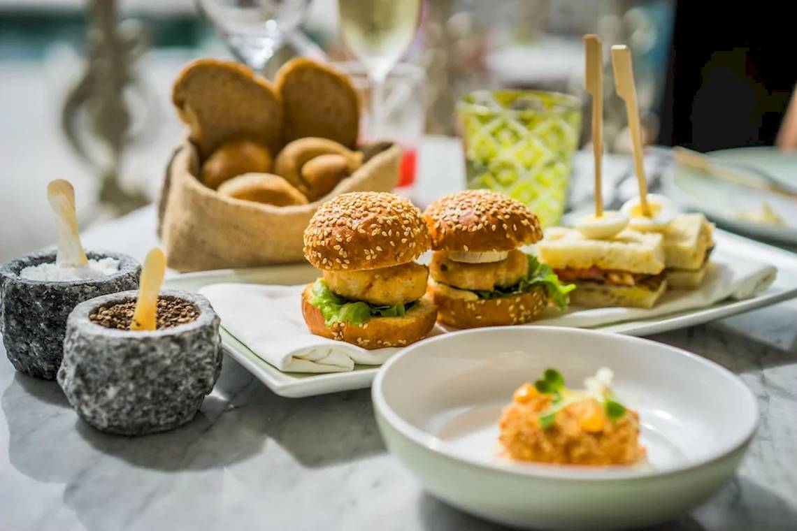 Frühstücksbuffet im Outrigger Mauritius Beach Resort mit Burgern, Sandwiches und anderen Speisen.
