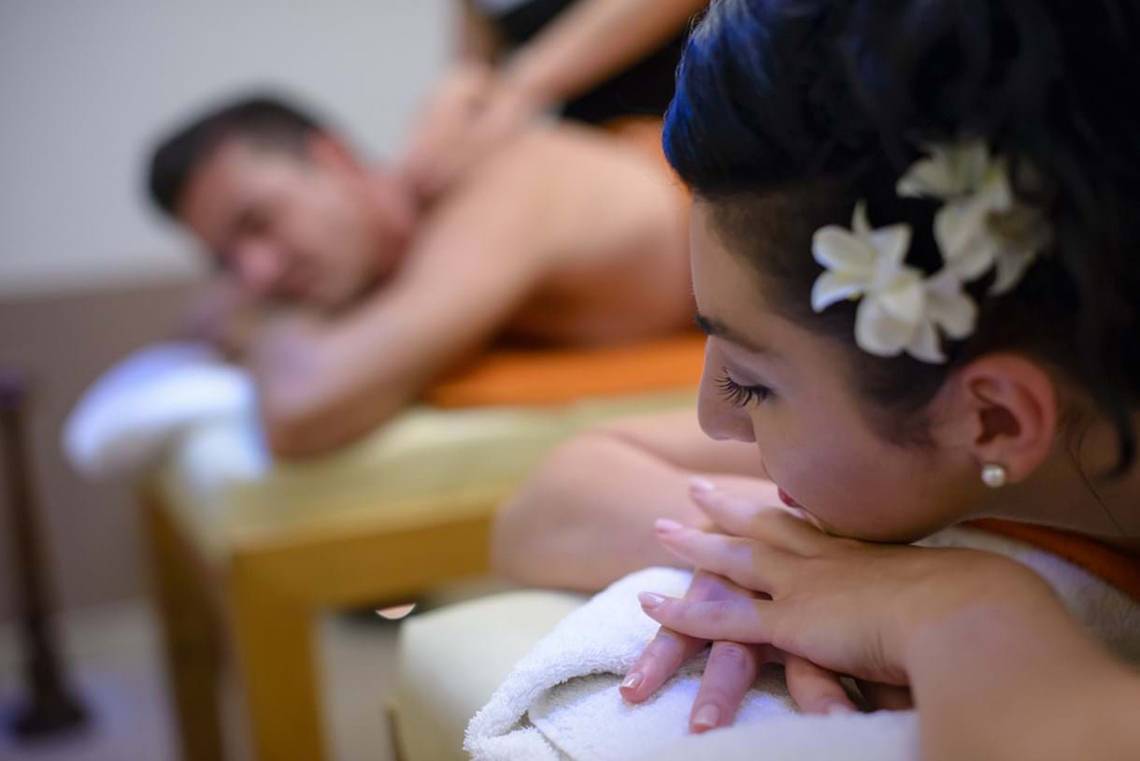 Massage im Royal Blue Resort, Mann und Frau mit Blumen im Haar.