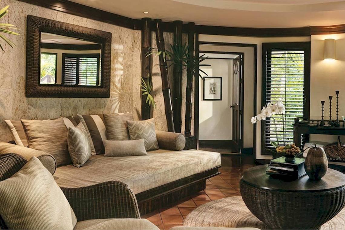 Wohnzimmer im Rayavadee Hotel mit einem Sofa, einem großen Spiegel und einem Tisch.