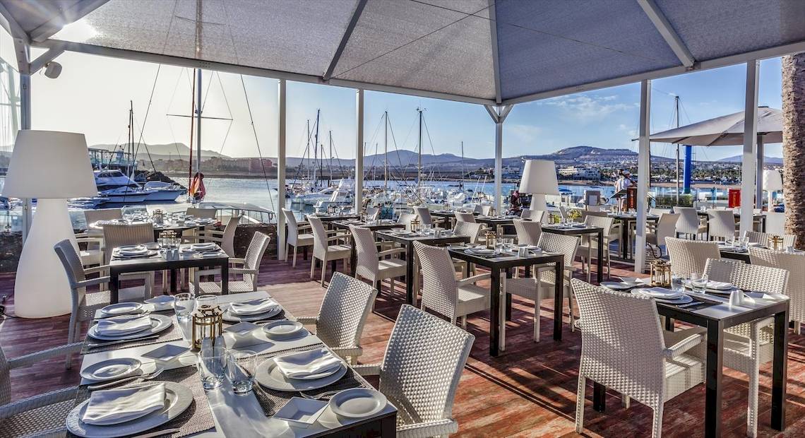 Terrasse des Barcelo Fuerteventura Castillo Hotels mit Blick aufs Meer und Yachten.