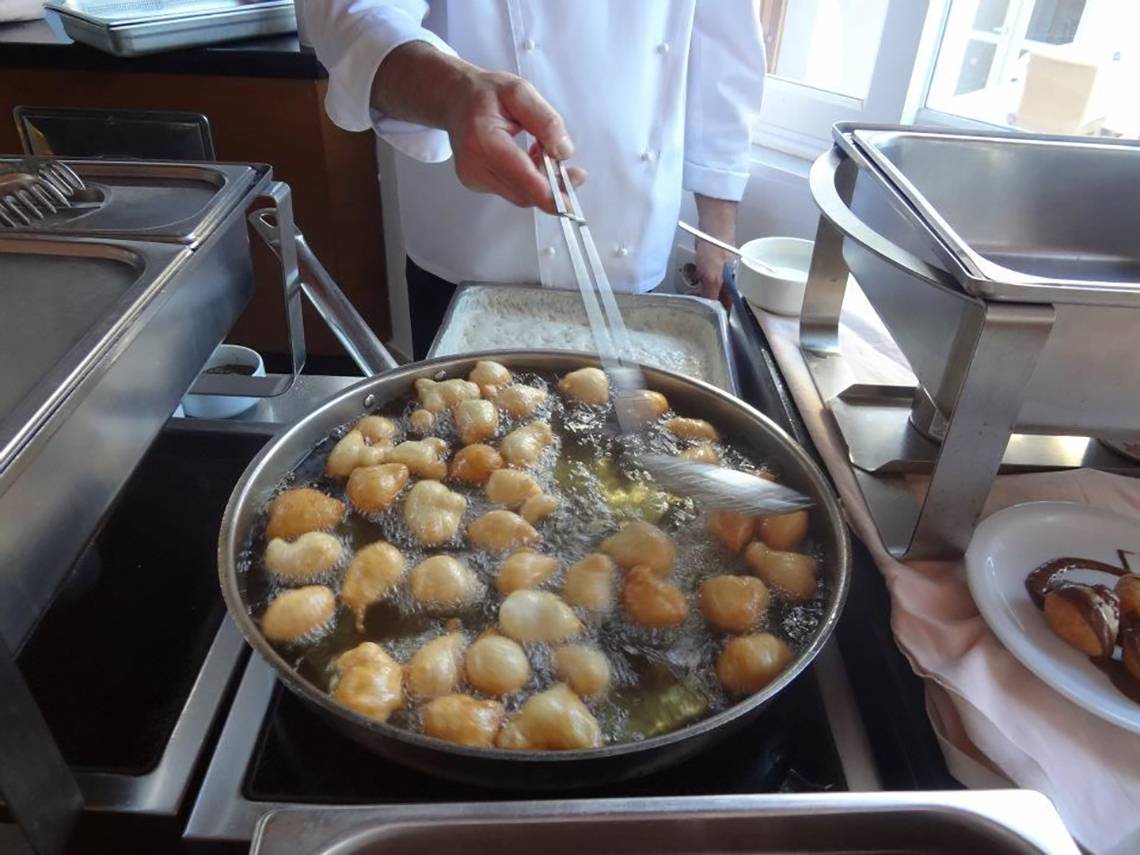 Koch im Platanista Hotel frittiert gefüllte Kugeln in einer Pfanne.