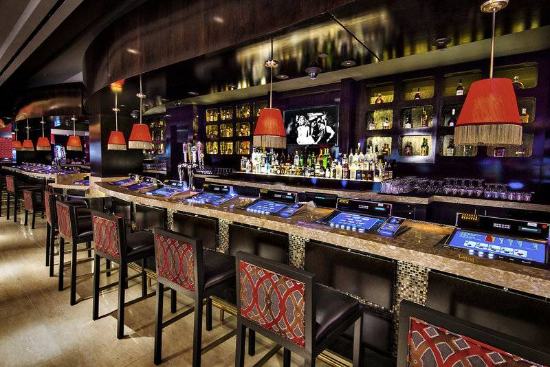 Die Bar im Cromwell Las Vegas Hotel & Casino mit Spielautomaten und roten Lampen.