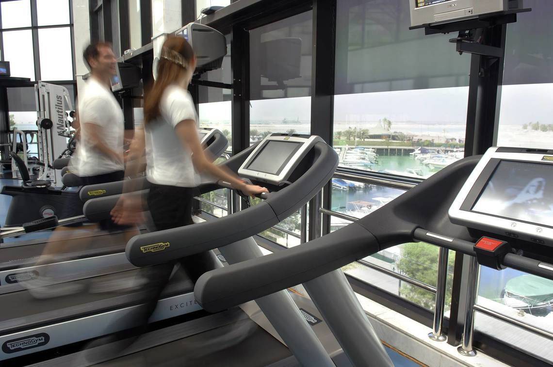 Fitnessstudio im Intercontinental Abu Dhabi mit zwei Personen, die auf Laufbändern laufen.