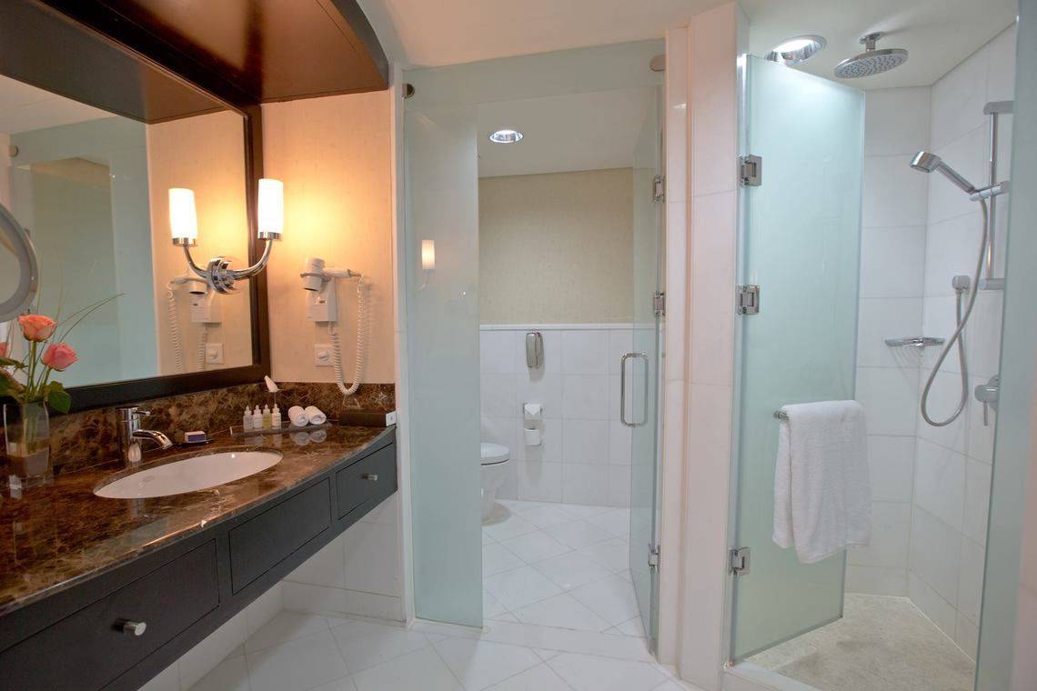 Badezimmer im Intercontinental Hotel in Abu Dhabi mit Glasdusche, Waschbecken und Spiegel.