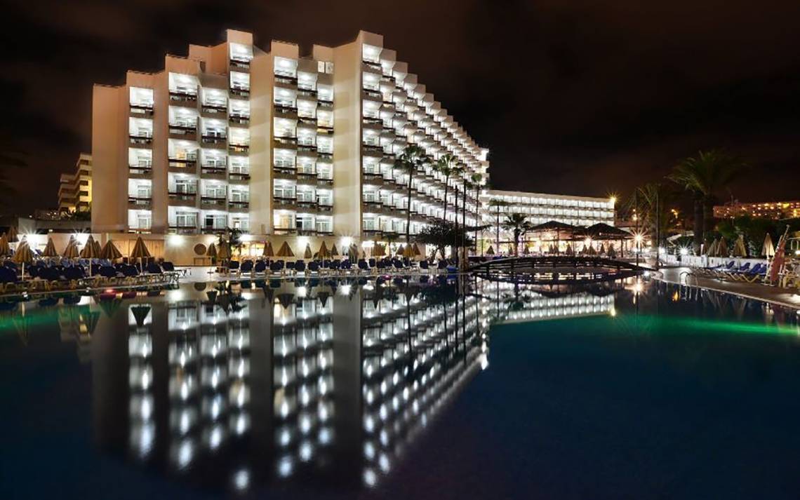 Alexandre Hotel Troya bei Nacht mit Pool und Hotelbeleuchtung.