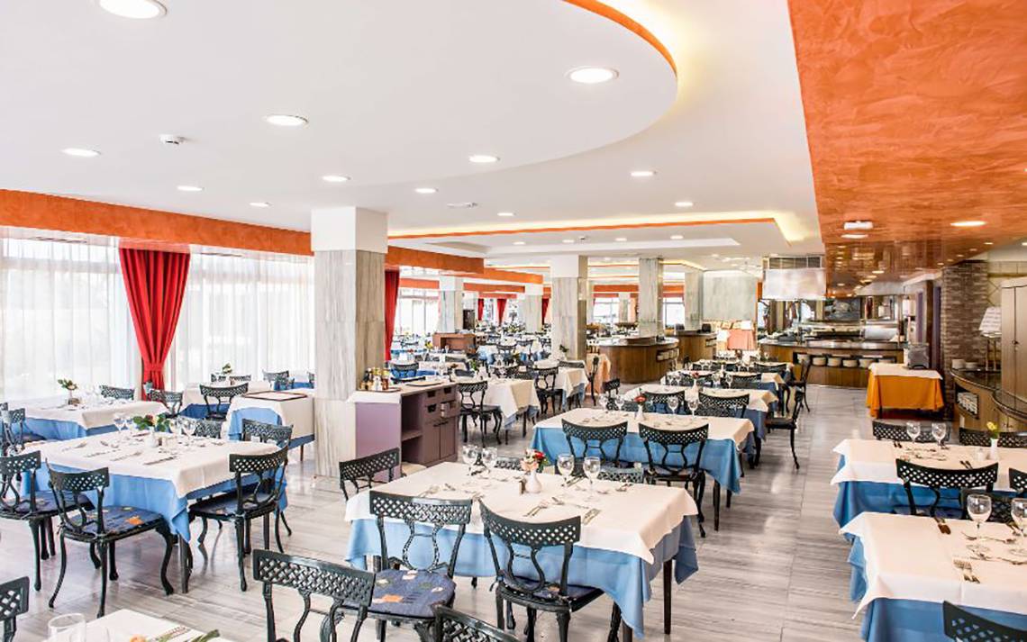 Innenbereich des Restaurants im Alexandre Hotel Troya mit gedeckten Tischen und Stühlen.