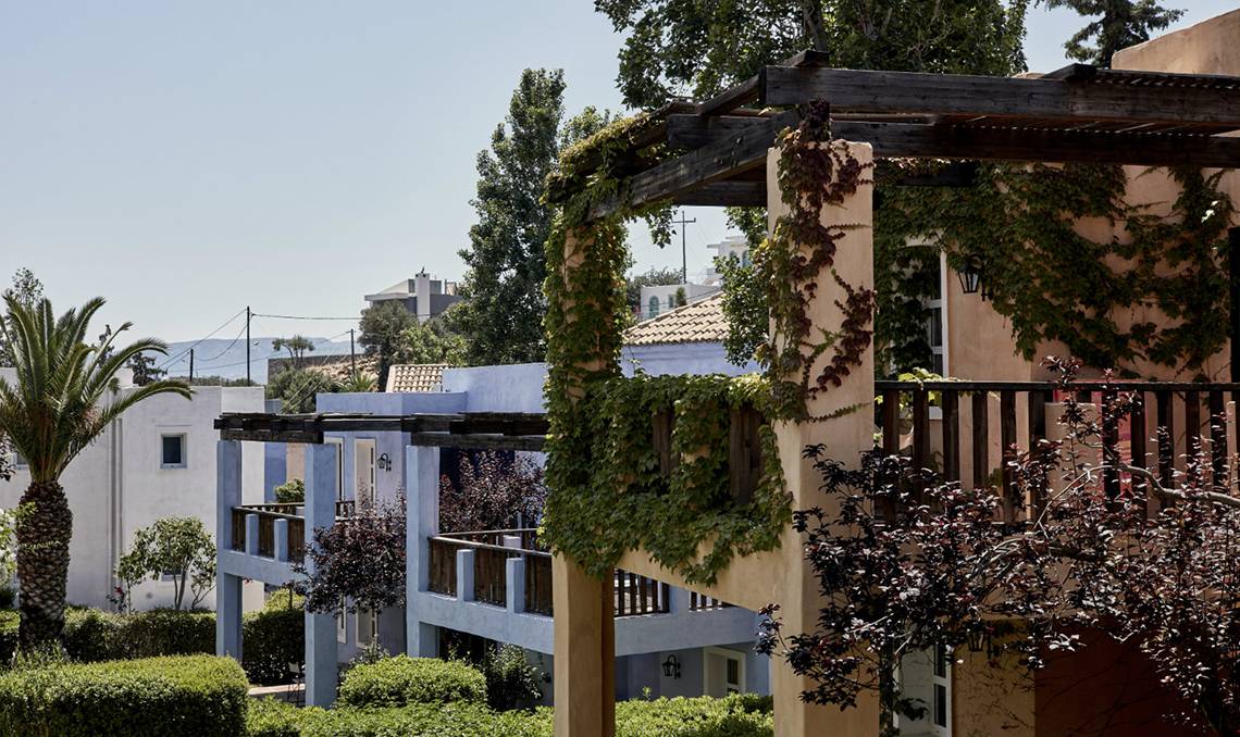 Aussenbereich des Candia Park Village Hotels mit Gebäuden, Terrassen und Bepflanzung.