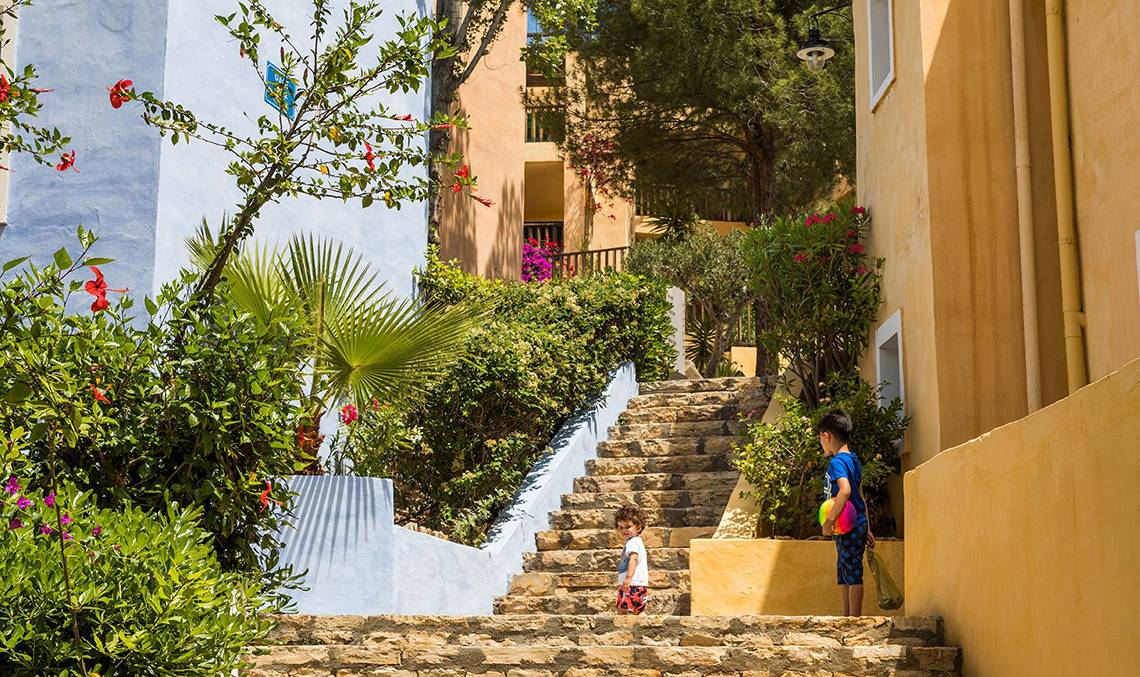 Zwei Kinder steigen die Treppe zum Candia Park Village auf.