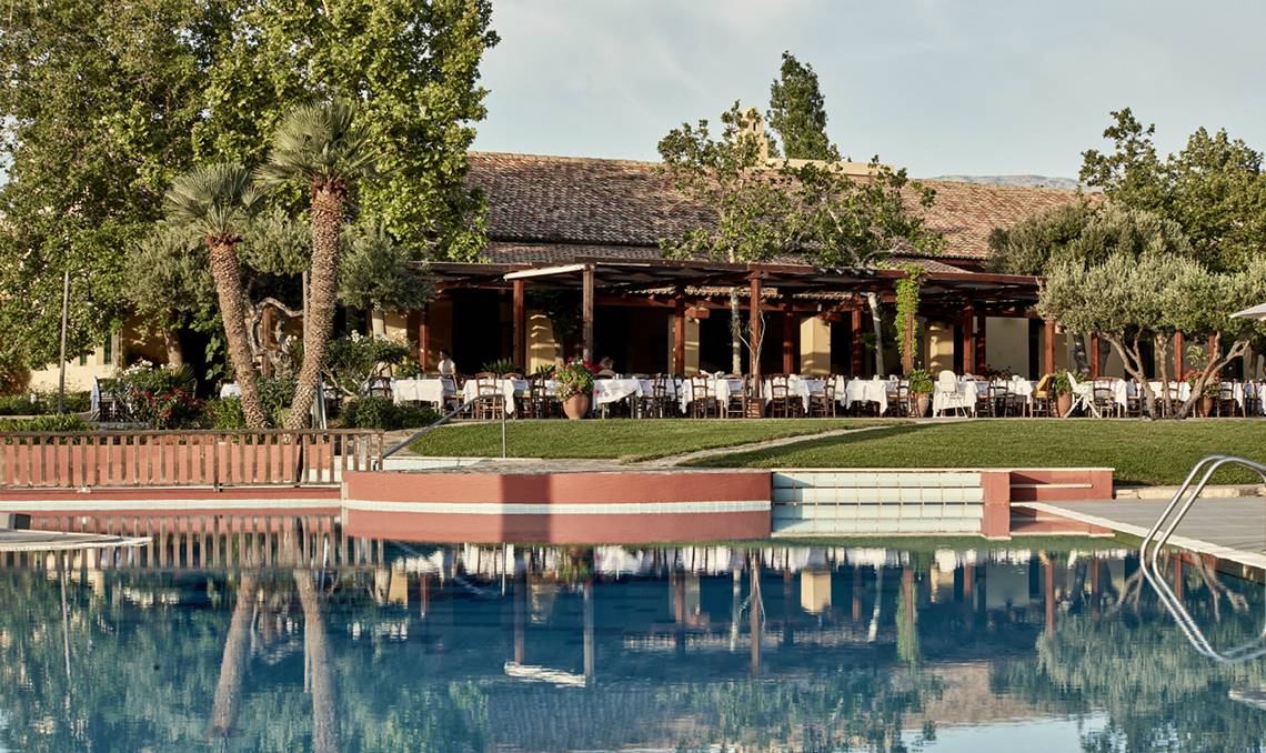 Außenansicht des Candia Park Village Hotels mit Swimmingpool und bewirtetem Restaurant.