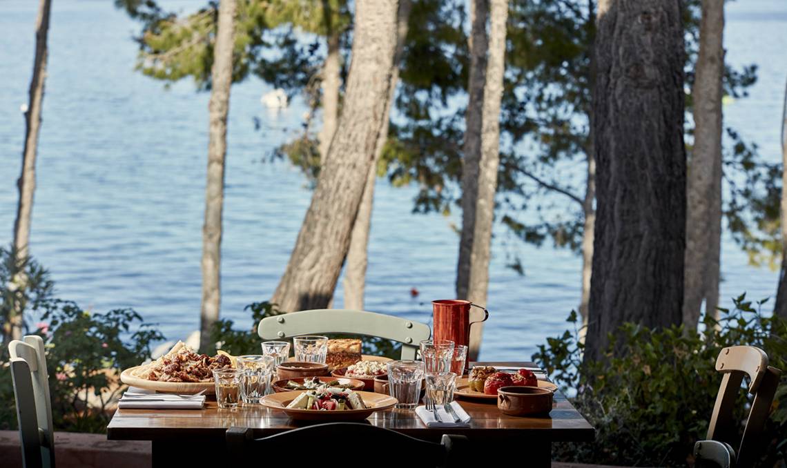 Terrasse im Candia Park Village mit Blick auf das Meer und serviertem Essen.