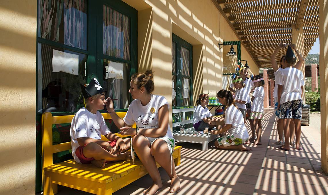 Kinderanimation im Candia Park Village mit einem Jungen, der eine Piratinnenmütze trägt, während eine Frau ihm die Wange streichelt.