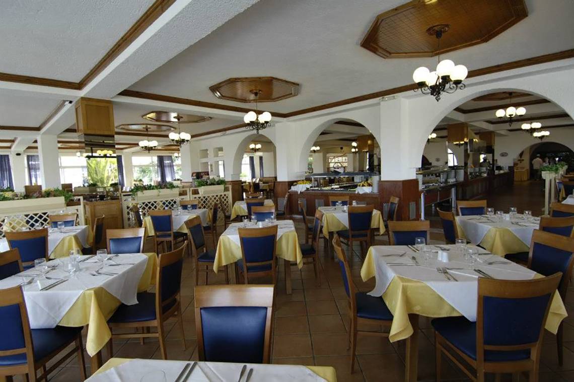 Restaurant des Porto Bello Beach Hotels mit blauen und gelben Tischdecken, Stühle und Lampen
