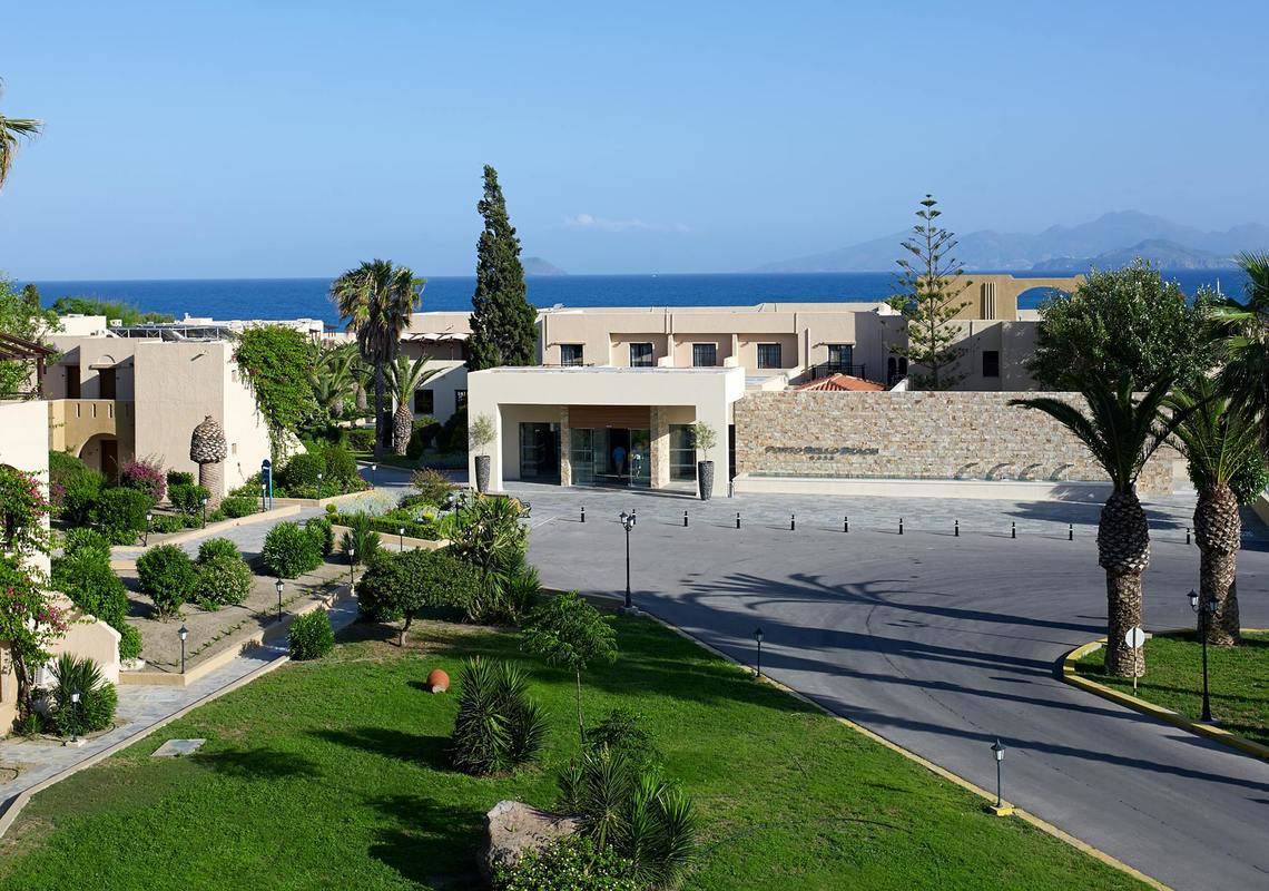 Außenansicht des Porto Bello Beach Hotels mit Blick auf den Eingang und das Meer