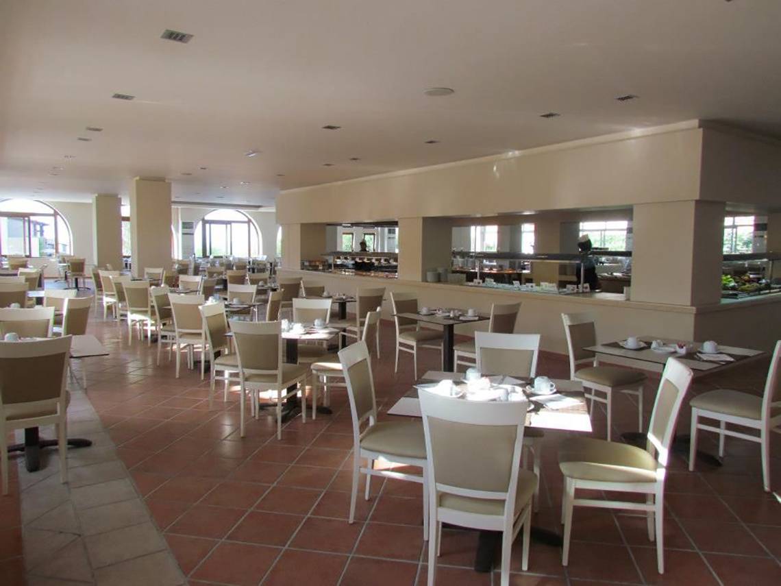 Frühstücksraum des Porto Bello Beach Hotels mit vielen Tischen und Stühlen.