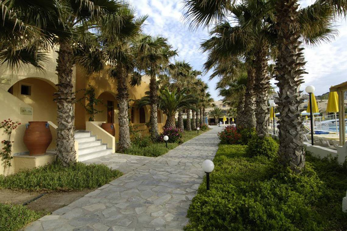 Foto des Eingangsbereichs des Porto Bello Beach Hotels mit gepflastertem Weg und Palmen