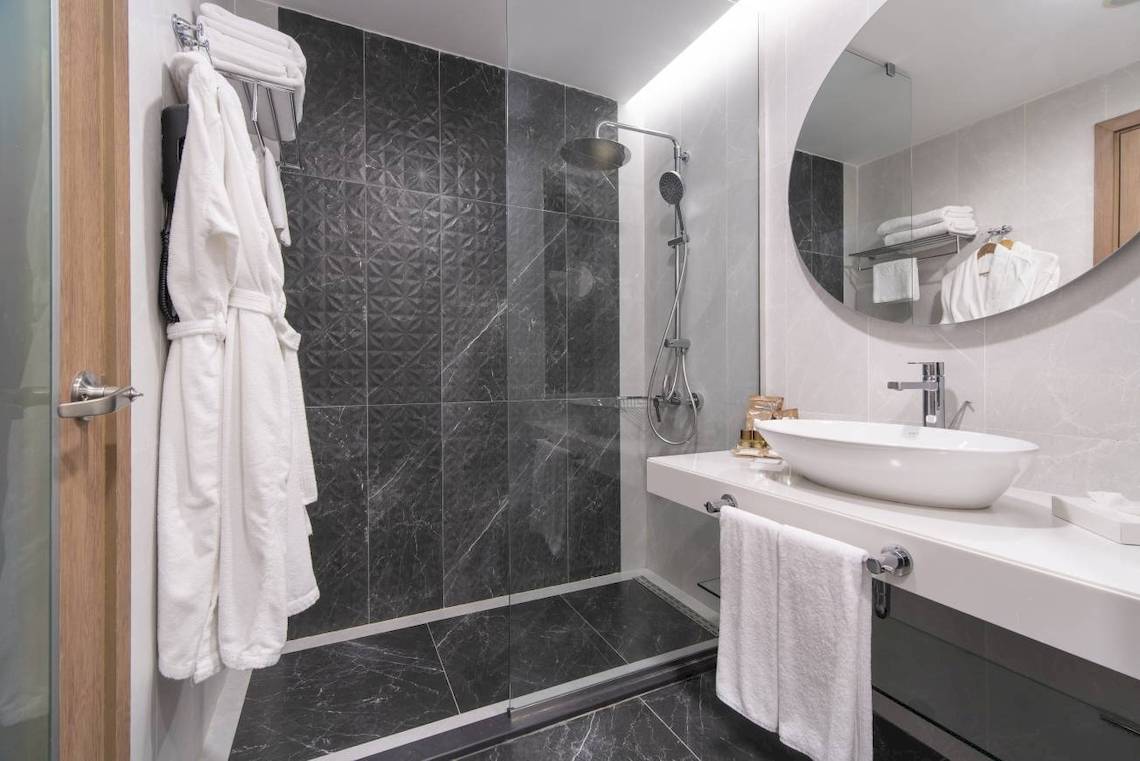 Badezimmer im Concorde De Luxe Resort mit Marmorboden und Glasdusche