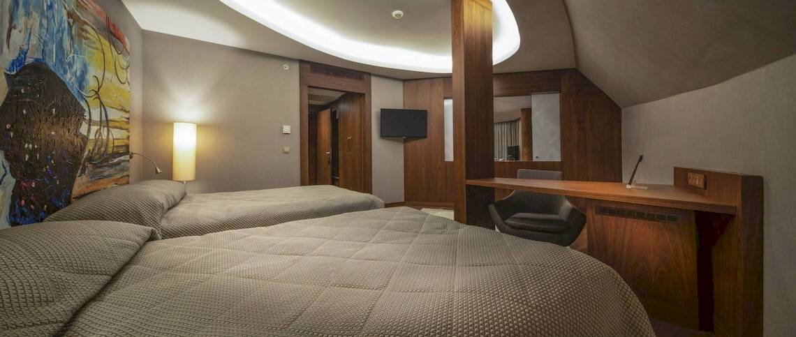 Schlafzimmer im Concorde De Luxe Resort mit zwei Betten, einem Schreibtisch und einem Fernseher.