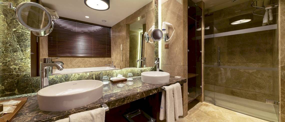 Badezimmer im Concorde De Luxe Resort mit zwei Waschbecken und einer Dusche.