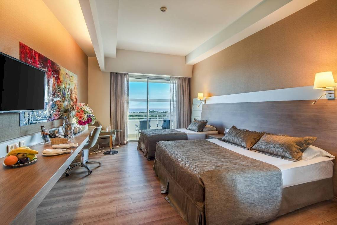 Hotelzimmer im Concorde De Luxe Resort mit zwei Betten, Fernseher, Schreibtisch und Balkon
