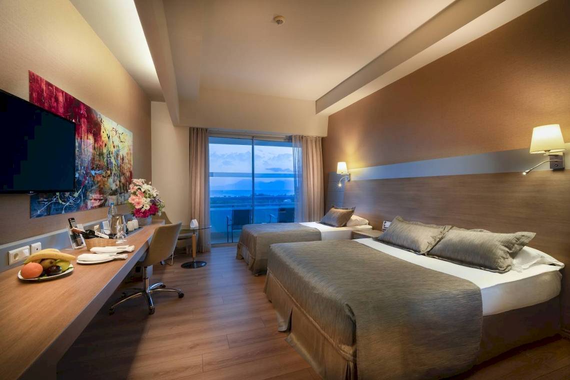 Doppelzimmer im Concorde De Luxe Resort mit Meerblick, zwei Betten, Schreibtisch und Fernseher.