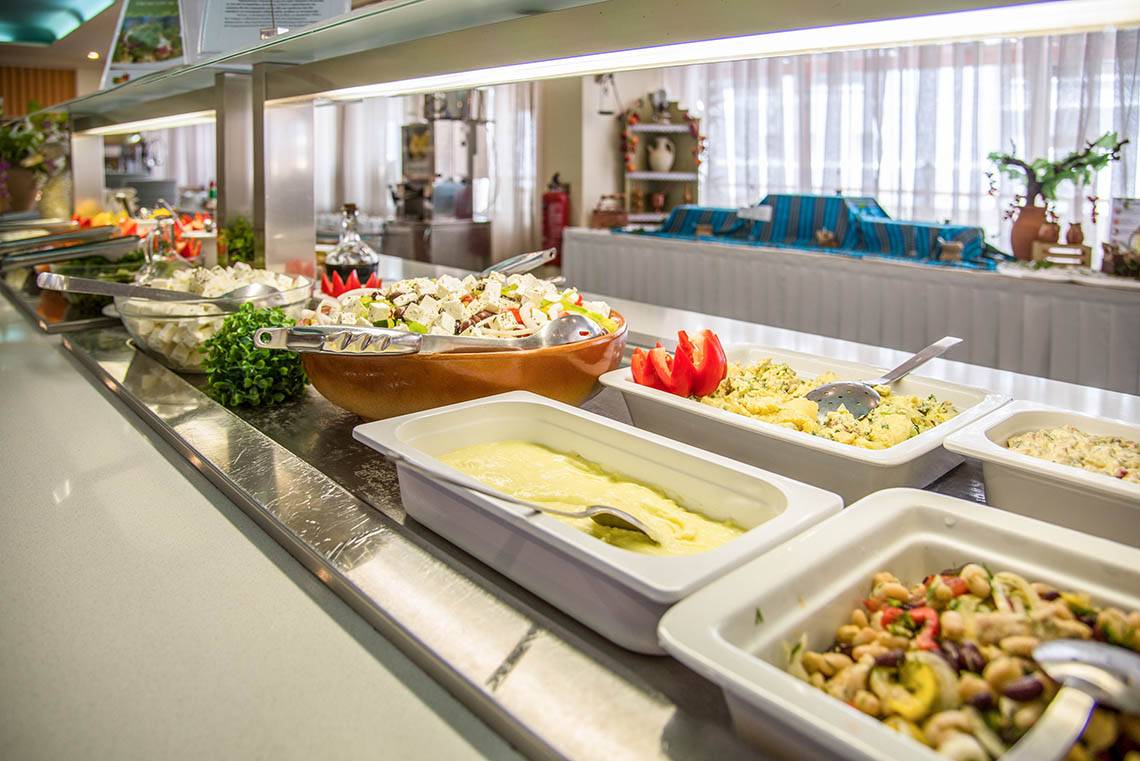 Buffet-Tisch im Kalyves Beach Hotel mit verschiedenen Gerichten und Salaten.