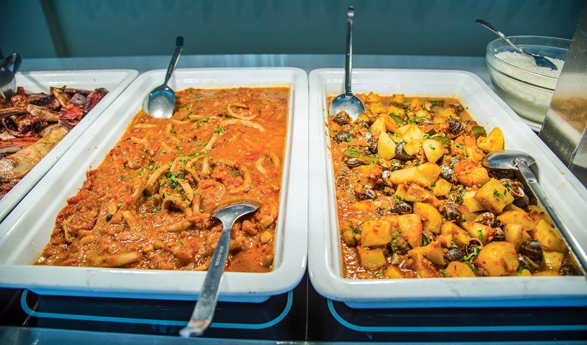 Buffet im Kalyves Beach Hotel mit verschiedenen Gerichten wie Meeresfrüchten und Fleisch.