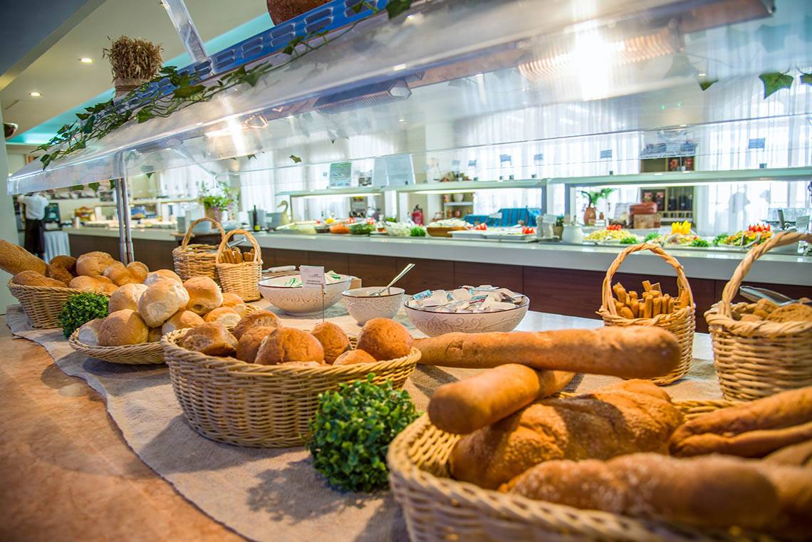 Frühstücksbuffet im Kalyves Beach Hotel mit verschiedenen Brotsorten in Körben.